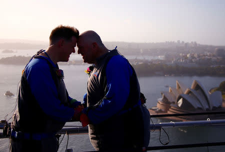 Warren Orlandi and Pauly Phillips react after they became the first same-sex couple to marry atop of the Sydney Harbour Bridge, just two days out from the 40th anniversary of the Sydney Gay and Lesbian Mardi Gras, in Australia, March 1, 2018. REUTERS/David Gray