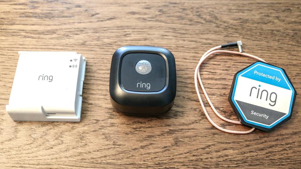 The Ring Mailbox Sensor next to a Ring Bridge on a table