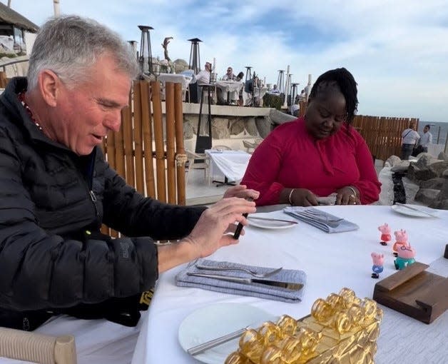 David Zielke of Sacramento, California takes a video of four Peppa Pig toys as waits on dinner with his family on a trip to Cabo San Lucas, Mexico.