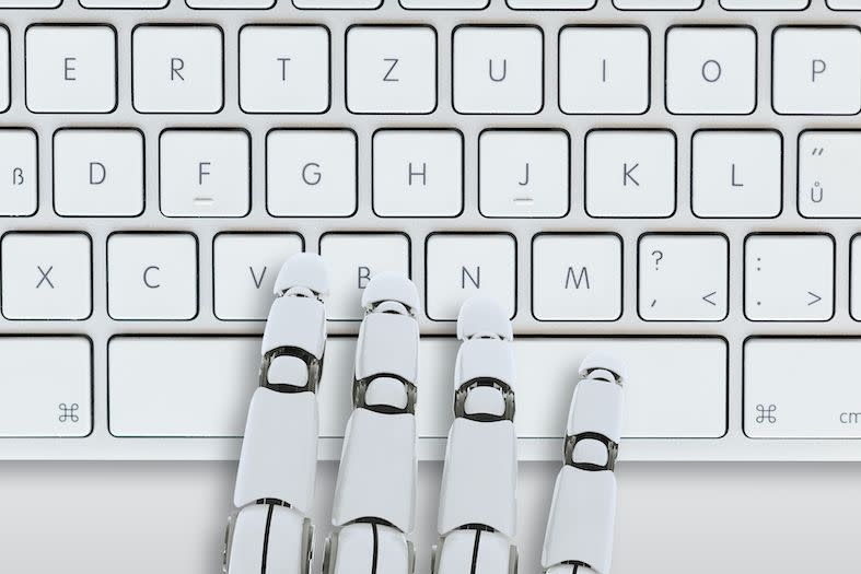 futuristic robotic hand typing on a keyboard