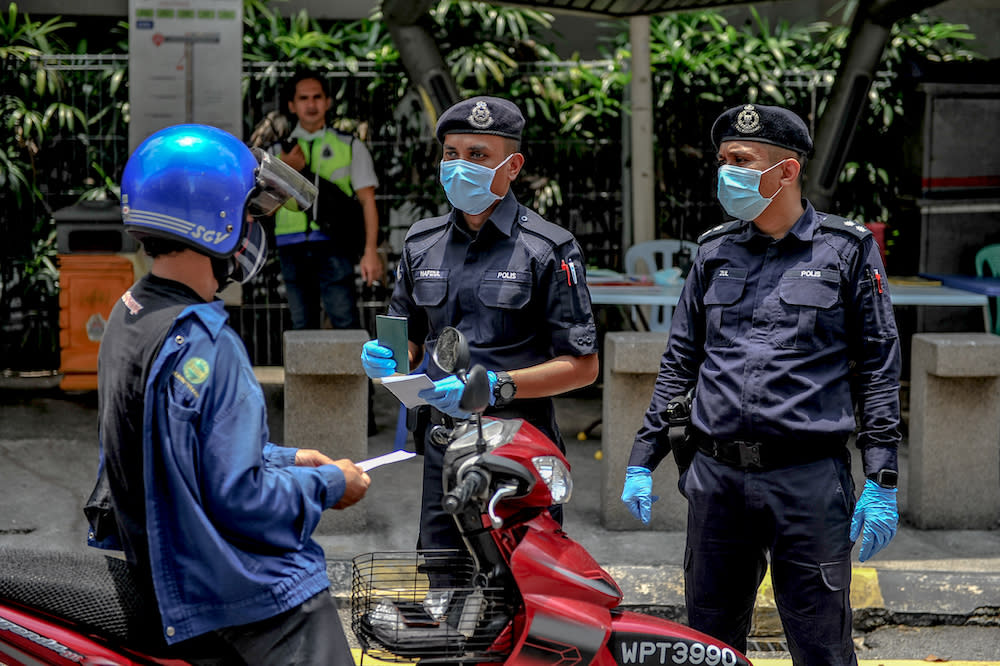 Soldiers and police officers conducting checks at a roadblock during the movement control order (MCO) in Kuala Lumpur March 29, 2020. — Picture by Firdaus Latif