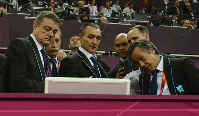 Human error caused the scoring error that kept Japan waiting for the silver medal in the Olympic gymnastics team event, and a robust review system quickly righted the wrong, a senior official said. Judges check the monitor after Japan's team complained at the men's gymnastics team final in the North Greenwich Arena during the London 2012 Olympic Games July 30, 2012.