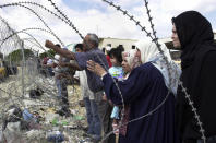 <p>Palestinians try to speak to Palestinian police through a fence as they wait to be processed for travel via the Rafah border crossing at the Egyptian border in southern Gaza Strip, Aug. 22, 2002. (Photo: Jacqueline Larma/AP) </p>