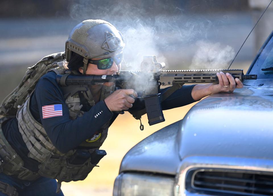 Former Congresswoman Tulsi Gabbard fires an M4 carbine from behind a vehicle during the 2021 Tactical Challenge at the U.S. Army John F. Kennedy Special Warfare Center and School's Miller Training Complex  on Dec. 16, 2021. Twelve celebrities teamed up with Green Berets to take part in the annual event.