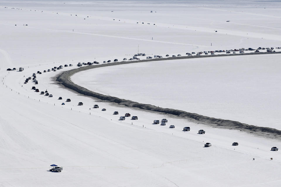 FILE - Cars form a line near the race track at the Bonneville Salt Flats near Wendover, Utah, on Aug. 13, 2016. The crust keeps tires cool at high speeds and provides an ideal surface for racing — unless seasonal flooding fails to recede or leaves behind an unstable layer of salt. (AP Photo/Rick Bowmer, File)