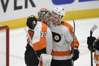 Philadelphia Flyers goaltender Brian Elliott (37) and center Scott Laughton (21) celebrate after the team's NHL hockey game against the Washington Capitals, Wednesday, March 4, 2020, in Washington. The Flyers won 5-2. (AP Photo/Nick Wass)