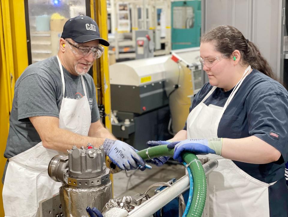 Jim Cox and Jazmine Powell work together on the factory floor at Cat's Pontiac campus.)