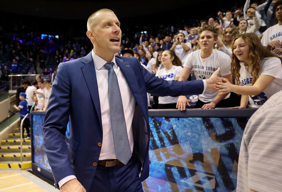 BYU men’s head basketball coach Mark Pope high-fives fans in the front row of the student section after BYU beat Bellarmine.