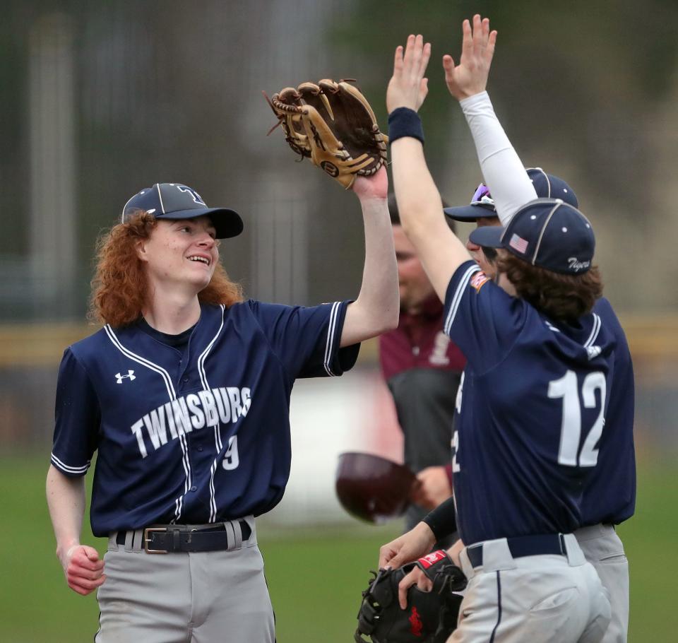 Twinsburg reliever Justin Adkins, left, high fives his teammates after the Tigers beat the Stow Bulldogs, 3-1, in a baseball game on Friday in Stow.