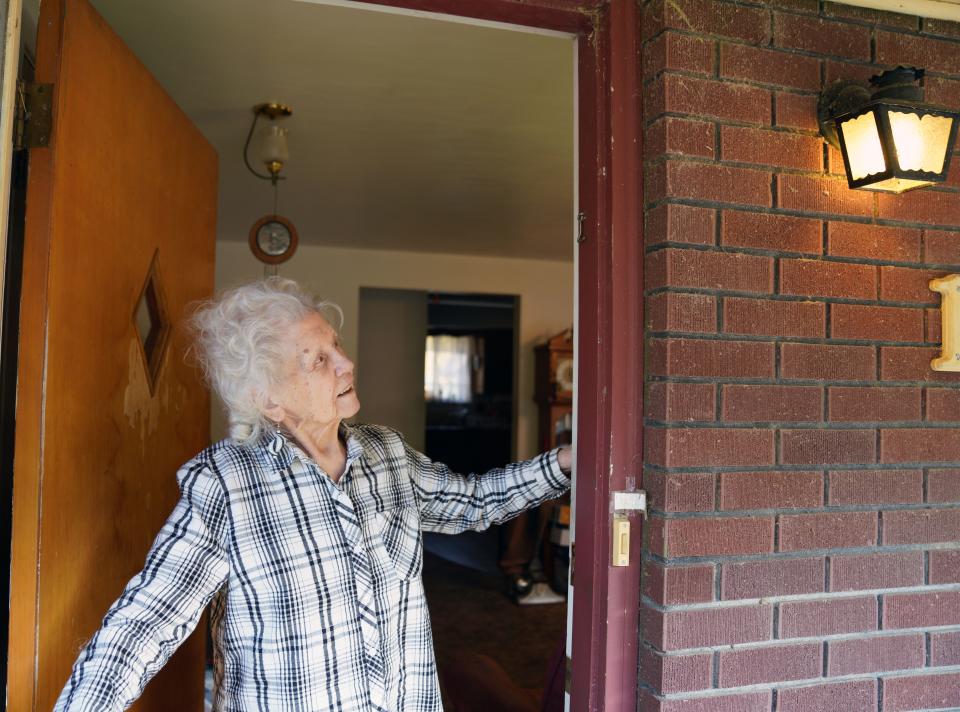 Antoinette "Toni" Stark, 99, points out an exterior light on her single-story home in Longmont, Colo. Stark has lived in the house since 1978, and now lives off Social Security and a small amount of savings, and uses heating assistance from the federal government to help pay her utility bills during the cold winters.