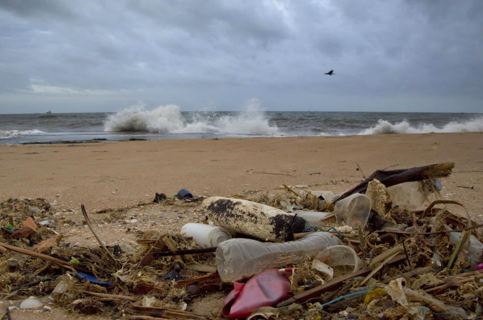 FILE - In this Aug. 13, 2015 file photo, a plastic bottle lies among other debris washed ashore on the Indian Ocean beach of Uswetakeiyawa, north of Colombo, Sri Lanka. According to a scientific report from the United Nations released on Wednesday, March 13, 2019, climate change, a global major extinction of animals and plants, a human population soaring toward 10 billion, degraded land, polluted air, and plastics, pesticides and hormone-changing chemicals in the water are making the planet an increasing unhealthy place for people. (AP Photo/Gemunu Amarasinghe, File)