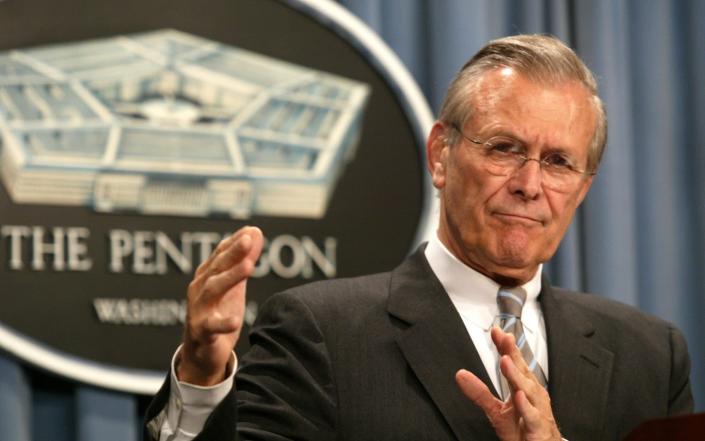 Donald Rumsfeld gestures during a press conference at the Pentagon