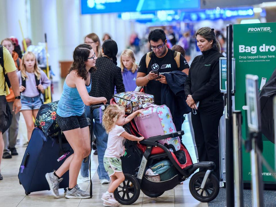 Travelers wait to check in for their flight at a Frontier ticket counter at Orlando International Airport during the busy Labor Day holiday weekend in Orlando 2023.