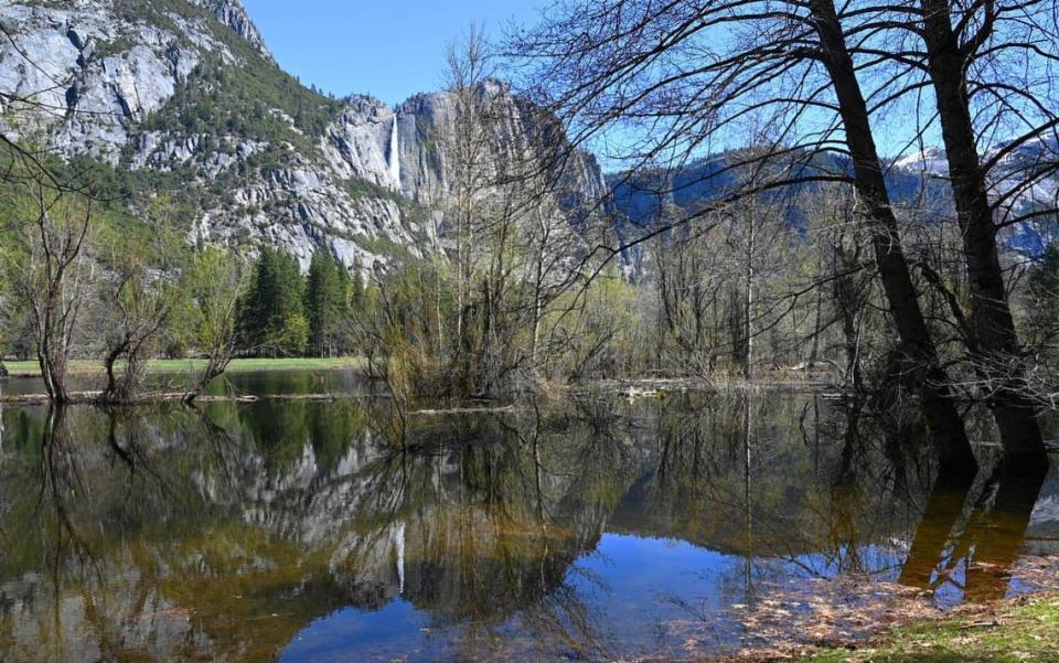 Upper Yosemite Fall is seen reflected in river overflow as park officials expect the Merced River to rise due to snow melt this weekend. Photographed Friday, April 28, 2023 in Yosemite Valley. ERIC PAUL ZAMORA/ezamora@fresnobee.com