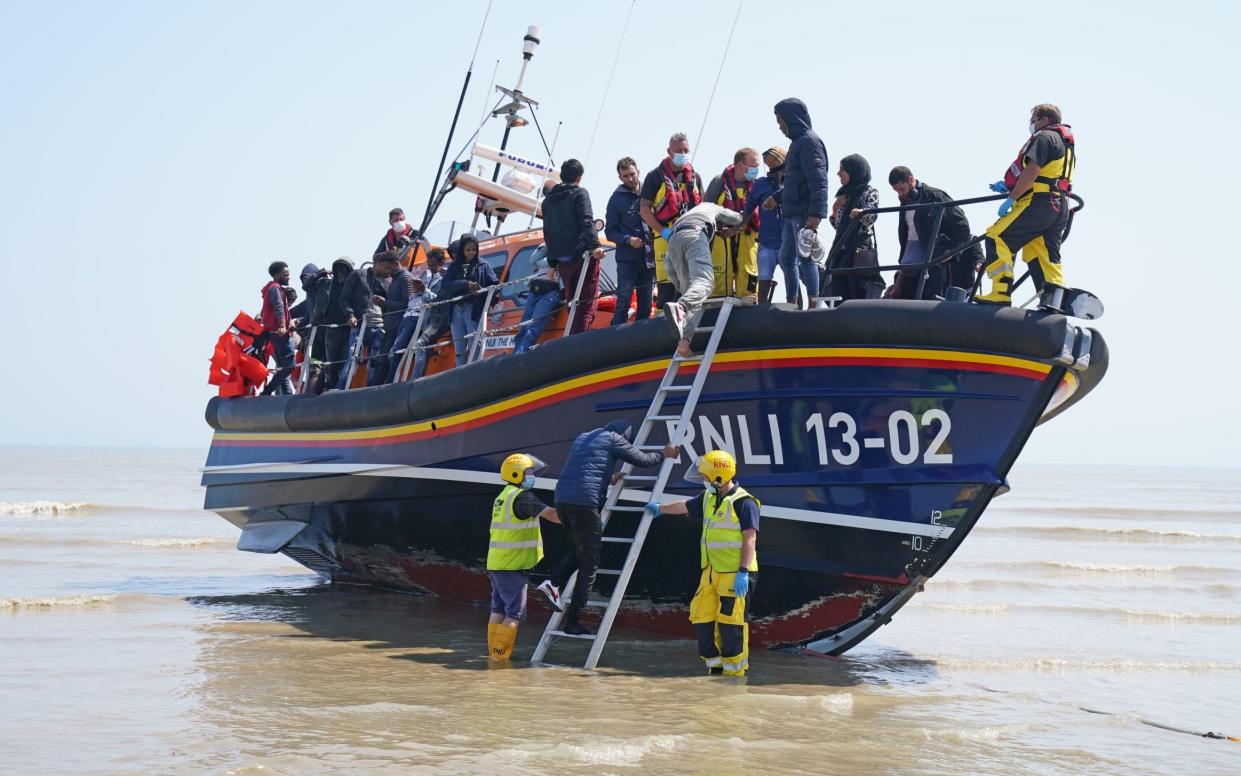 A group of people thought to be migrants crossing from France come ashore from the local lifeboat at Dungeness in Kent, after being picked up from a small boat in the Channel - Gareth Fuller/PA
