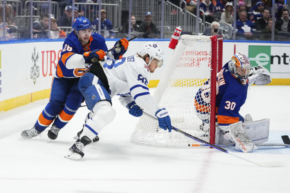 Toronto Maple Leafs' William Nylander (88) drives past New York Islanders' Alexander Romanov (28) as Islanders goaltender Ilya Sorokin (30) protects the net during the third period of an NHL hockey game Thursday, Jan. 11, 2024, in Elmont, N.Y. (AP Photo/Frank Franklin II)