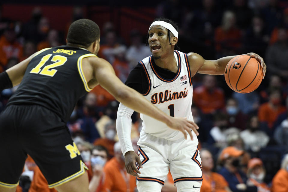 Illinois' Trent Frazier (1) shouts to a teammate as Michigan's DeVante' Jones defends during the first half of an NCAA college basketball game Friday, Jan. 14, 2022, in Champaign, Ill. (AP Photo/Michael Allio)