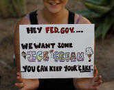 PHOENIX, AZ - OCTOBER 17: A woman holds her sign during the occupy Phoenix protest October 17, 2011 in Phoenix, Arizona. The movement which started with protesters occupying Wall Street in New York City has spread to cities around the United States. (Photo by Joshua Lott/Getty Images)