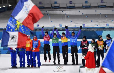 Biathlon - Pyeongchang 2018 Winter Olympics - Mixed Relay Final - Alpensia Biathlon Centre - Pyeongchang, South Korea - February 20, 2018 - Gold medalists: Martin Fourcade, Simon Desthieux, Marie Dorin Habert and Anais Bescond of France, silver medalists: Marte Olsbu, Tiril Eckhoff, Johannes Thingnes Boe and Emil Hegle Svendsen of Norway, bronze medalists: Lisa Vitozzi, Dorothea Wierer, Lukas Hofer and Dominik Windisch of Italy celebrate during the victory ceremony. REUTERS/Toby Melville