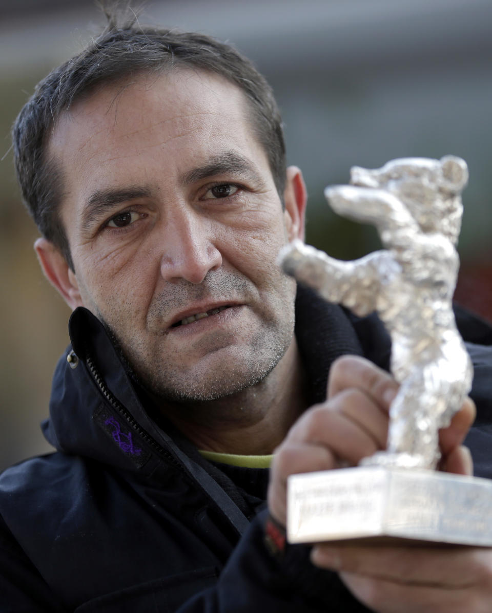 In this photo taken Saturday, Jan. 25, 2014, Bosnian actor Nazif Mujic holds his Silver Bear Best Actor award for his role in 'An Episode In the Life of an Iron Picker' prior to an interview with the Associated Press in Berlin, Germany. Mujic, a Roma from a tiny village in Bosnia, won the Silver Bear award in the year 2013. Now, almost a year later, the movie star has turned into an asylum seeker. Mujic is back in Berlin, but this time he came with his family to apply for asylum, was rejected by the German authorities and is desperately fighting his deportation back to Bosnia in March. (AP Photo/Michael Sohn)