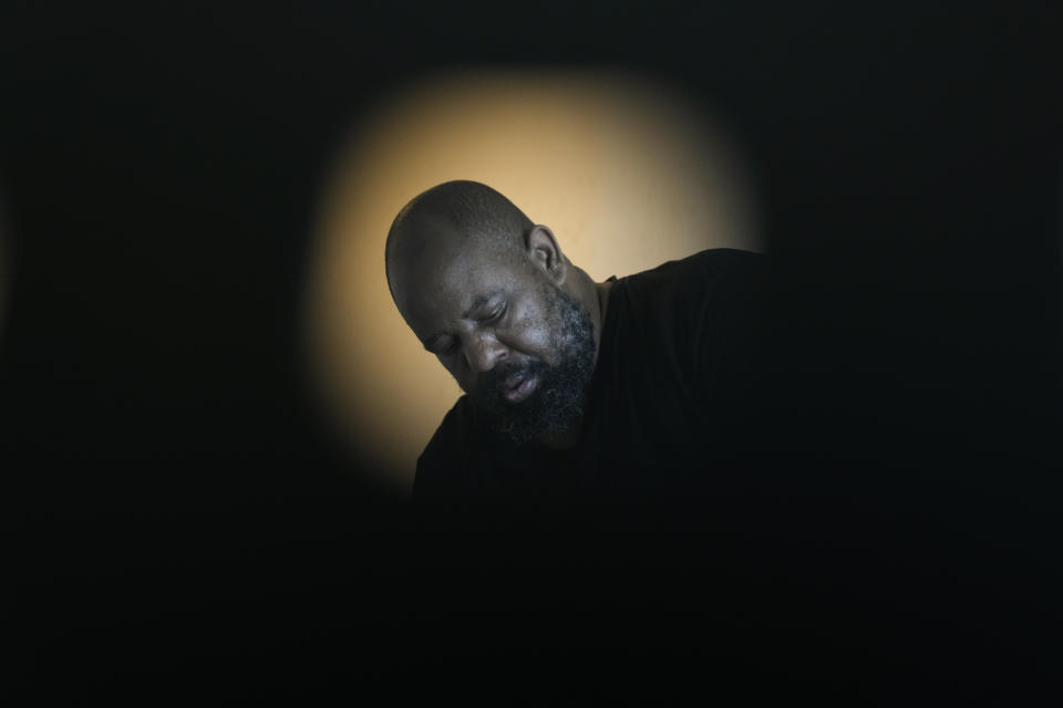 Freddie Davis, whose landlord raised his rent by 60 percent in the same month he lost his job as a truck driver, is seen through a hole in an office chair as he organizes moving his belongings to a storage unit after receiving a final eviction notice at his one-bedroom apartment, Wednesday, Sept. 29, 2021, in Miami. (AP Photo/Rebecca Blackwell)