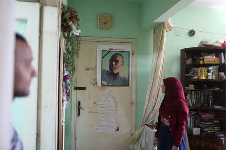 The son, Khaled (L), and daughter, Asmaa, of Mahmoud Abdel Hadi pose for a picture in front of a photograph of their father at the family home in the Nile Delta city of Mansoura, Egypt, July 28, 2015. REUTERS/Asmaa Waguih