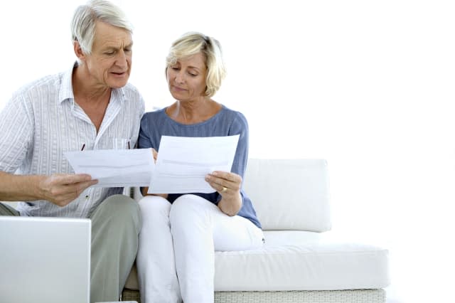 Senior couple doing home finances. White background with copy space.