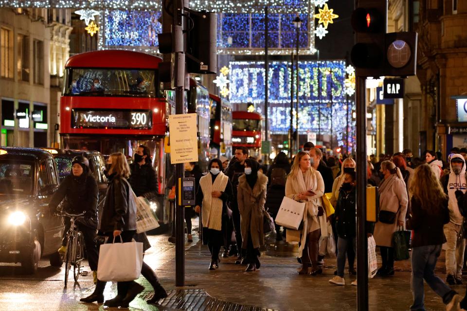 Shoppers and pedestrians pass under the Christmas lights on Oxford Street in central London on December 14, 2020, as it is announced that Greater London will be moved into Tier 3 from Tier 2 from Wednesday December 16. - London is to move into the highest level of anti-virus restrictions, the health minister announced Monday. The British capital from Wednesday will go into "tier three" restrictions, which force the closure of theatres and ban people from eating out at restaurants or drinking in pubs, the Health Secretary Matt Hancock told parliament. (Photo by Tolga Akmen / AFP) (Photo by TOLGA AKMEN/AFP via Getty Images)