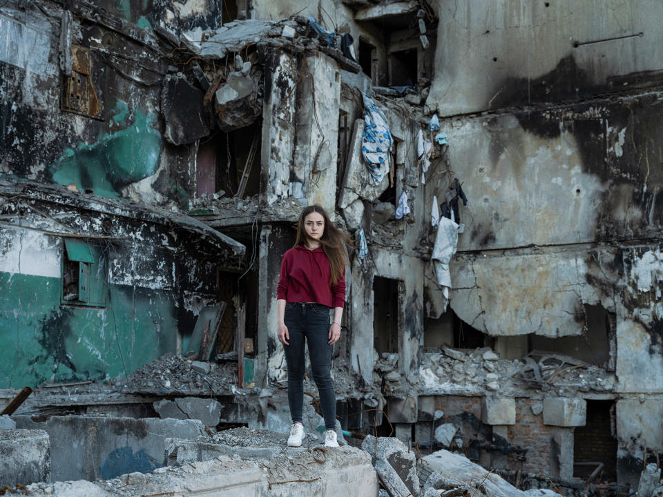 Katya Baranivska, 22, standing in front of the destroyed building in Borodyanka, Ukraine, where her family's apartment used to be before it was destroyed by a Russian bombing.<span class="copyright">Sasha Maslov—INSTITUTE</span>