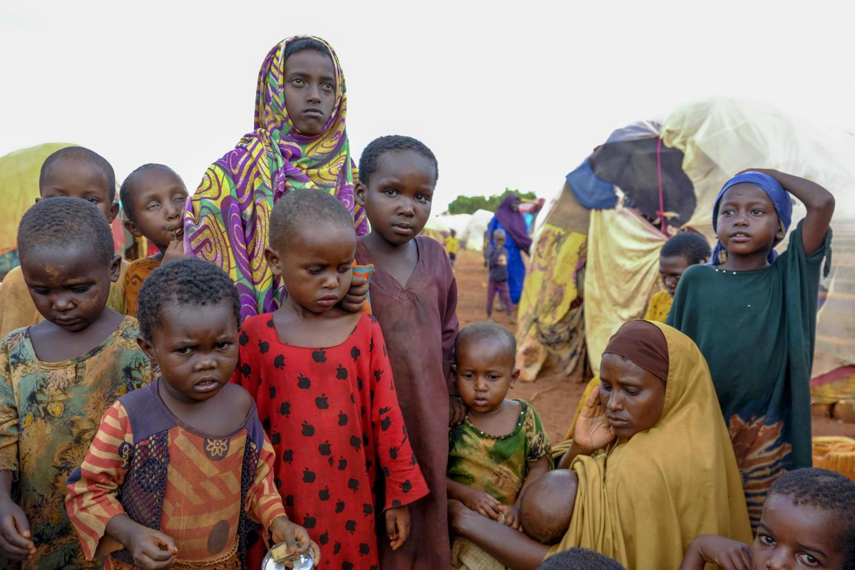 A mother and children displaced by drought sit outside their makeshift shelter on the outskirts of Baidoa, in Somalia Saturday, Oct. 29, 2022. Ships loaded with grain departed Ukraine on Tuesday, Nov. 1, 2022 despite Russia suspending its participation in a U.N.-brokered deal that ensures safe wartime passage of critical food supplies meant for parts of the world struggling with hunger such as Somalia. (AP Photo/Mohamed Sheikh Nor)