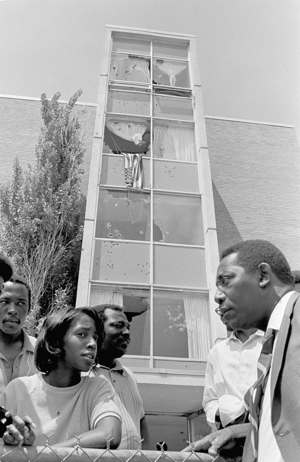 FILE - In this May 15, 1970, file photo, Mayor Charles Evers, of Fayette, Miss., a civil rights leader, talks with students outside the bullet-riddled women's dormitory at Jackson State College, in Jackson, Miss., where two young African-Americans were shot to death by police. More than a half century late, Jackson State University, in Mississippi, is honoring its Class of 1970, on Saturday, May 15, 2021. Commencement was canceled after white law enforcement officers marched onto campus of the historically Black school and violently suppressed protests against racism. (AP Photo, File)