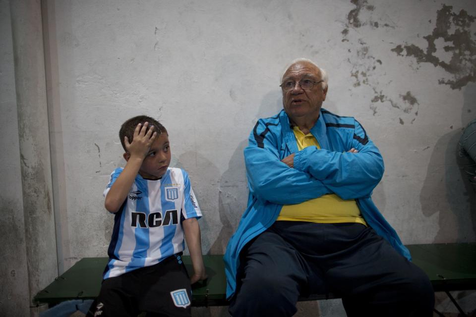 En esta foto del 11 de noviembre de 2016, el descubridor de talentos futbolísticos para el Club Social Parque y la división infantil de Boca Juniors, Ramón Maddoni, está sentado en una banca junto con el joven jugador Benjamín Palandella en la academia de futbol juvenil Club Social Parque, en un vecindario de clase trabajadora en Buenos Aires, Argentina. “Aquí trabajamos mucho los fundamentos, la técnica. Lo reconocemos desde chico. Se nos ha ido afilando cada vez más la vista”, (AP Foto/Natacha Pisarenko)