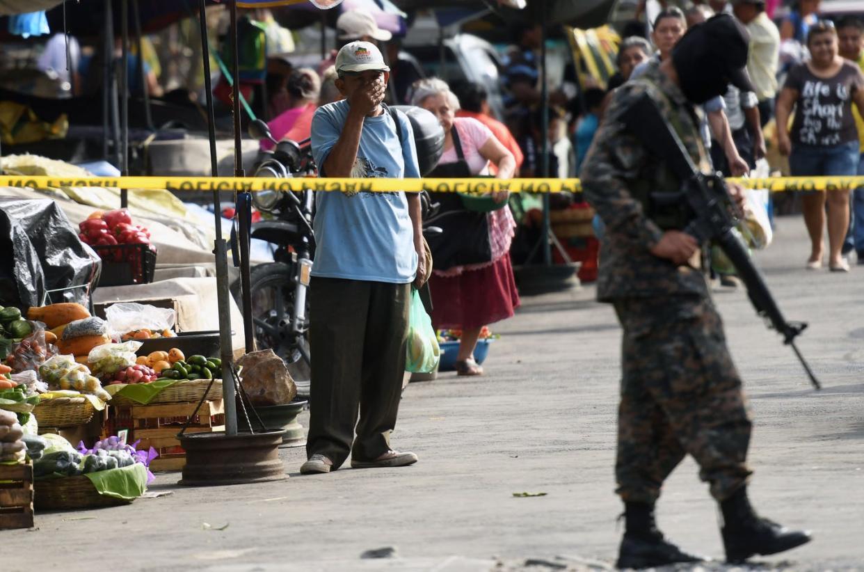 <span class="caption">Street gangs that operate with impunity make El Salvador one of the world's most violent countries. Few murders are ever solved.</span> <span class="attribution"><a class="link " href="https://www.gettyimages.com/detail/news-photo/soldier-stands-guard-at-the-crime-scene-where-five-market-news-photo/653621078?adppopup=true" rel="nofollow noopener" target="_blank" data-ylk="slk:MARVIN RECINOS/AFP via Getty Images;elm:context_link;itc:0;sec:content-canvas">MARVIN RECINOS/AFP via Getty Images</a></span>