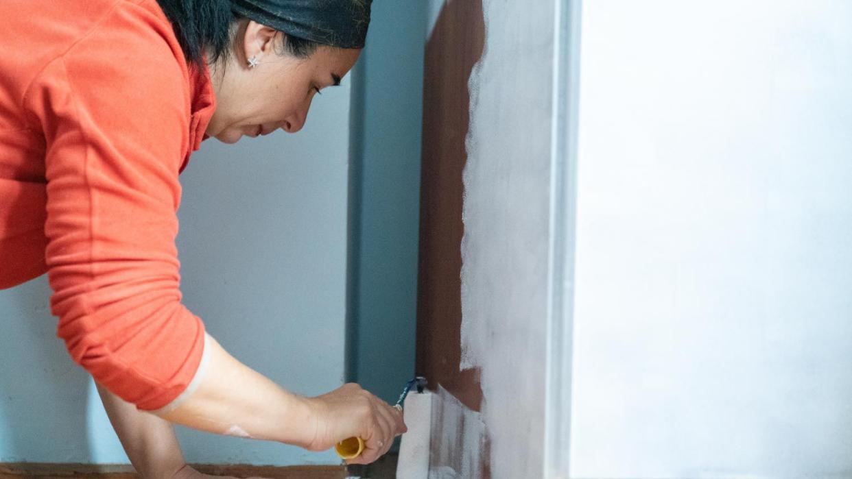 A woman painting a wardrobe at home