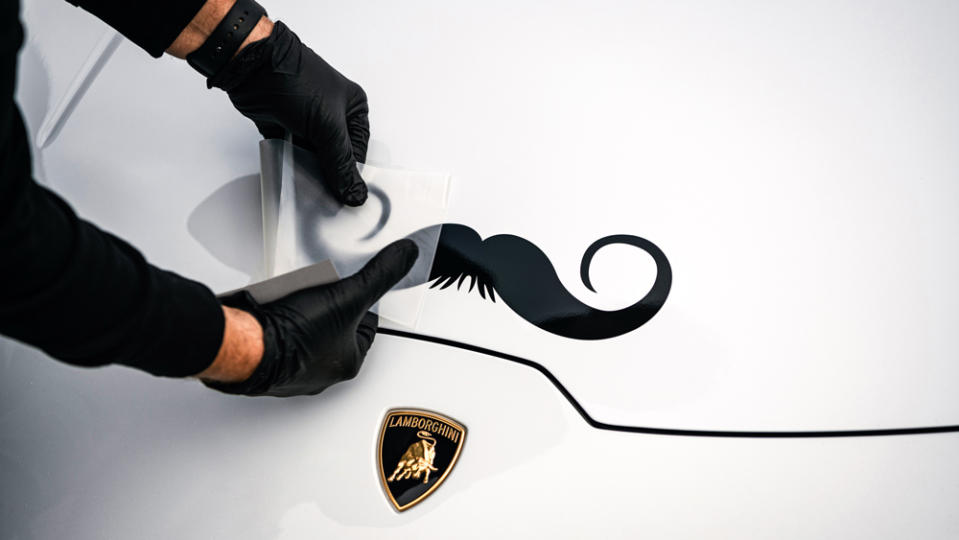 A Lamborghini receives a decal of a moustache, the symbol of Movember and raising awareness for men's health.