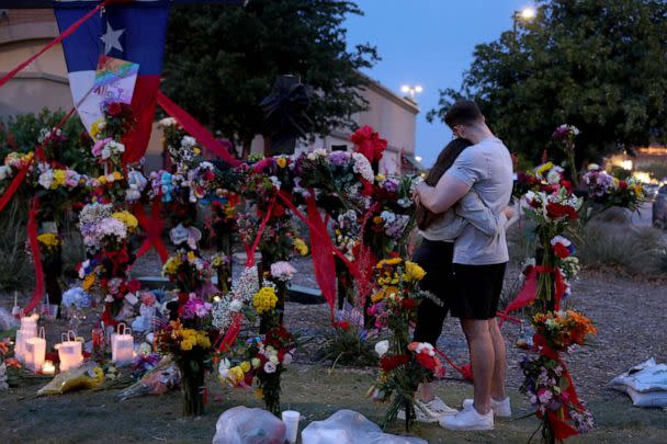 PHOTO: People hug as they visit the memorial next to the Allen Premium Outlets, May 7, 2023 in Allen, Texas. (Joe Raedle/Getty Images)