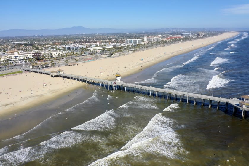 HUNTINTON BEACH, CA -- WEDNESDAY, APRIL 22, 2020: An aerial view of beach-goers enjoying warm summer-like weather amid state and city social distancing regulations mandated by Gov. Newsom at the closed Huntington Beach pier in Huntington Beach, CA, on April 22, 2020. The Orange County officials have been debating whether to close beaches and trailheads during an upcoming heat wave after coastal residents raised concerns about out-of-towners descending on their communities in droves. (Allen J. Schaben / Los Angeles Times)