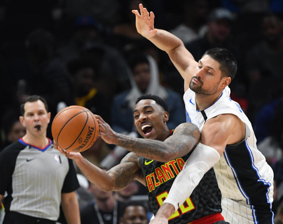 Atlanta Hawks guard Jeff Teague and Orlando Magic center Nikola Vucevic (9) vie for a rebound during the second half of an NBA basketball game Wednesday, Feb. 26, 2020, in Atlanta. Orlando won 130-120. (AP Photo/John Amis)