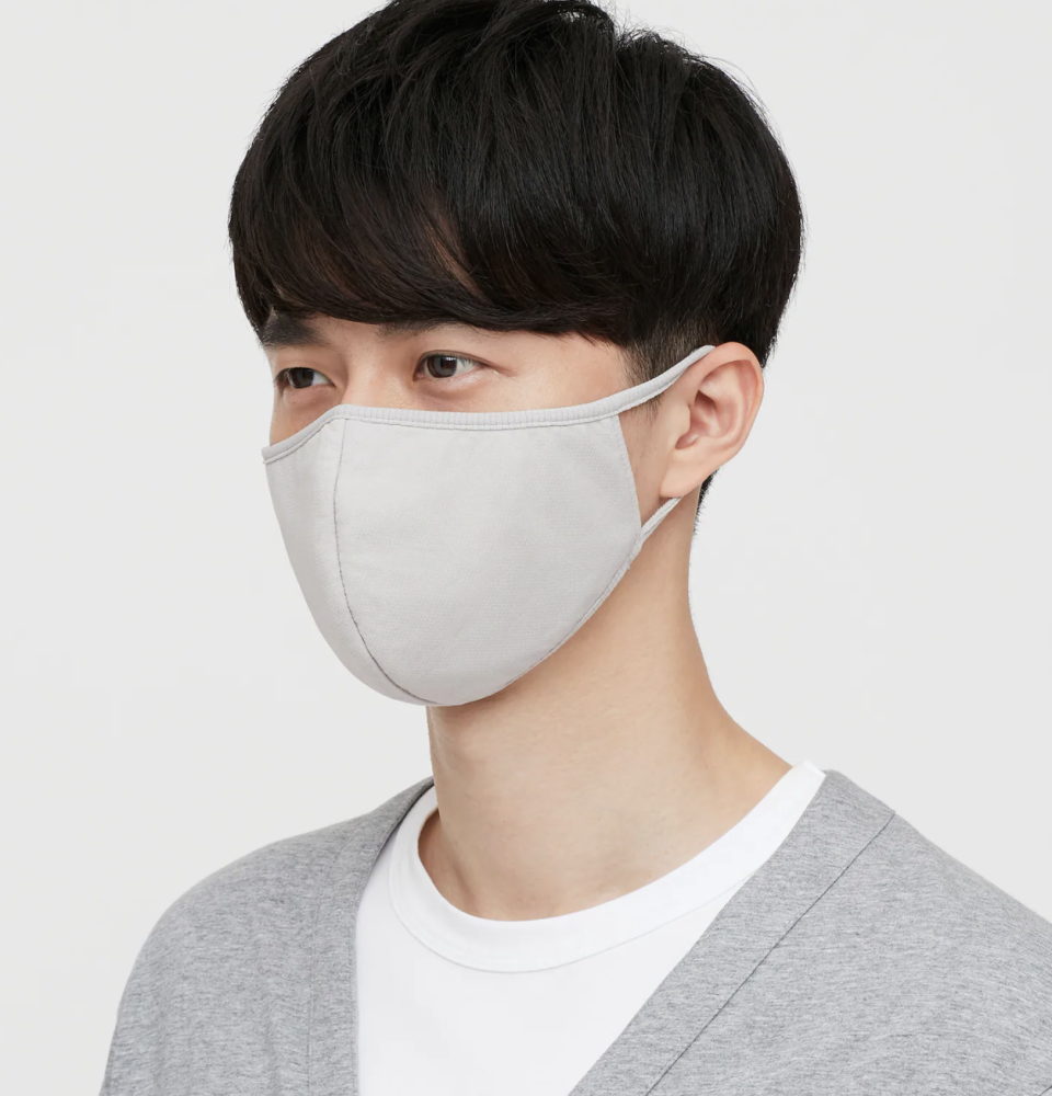 asian man wearing grey face mask, white t-shirt, and grey cardigan