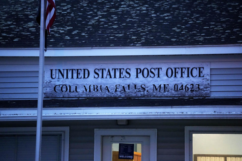 A weathered sign at the post office in Columbia Falls, Maine, Wednesday, April 27, 2023. (AP Photo/Robert F. Bukaty)