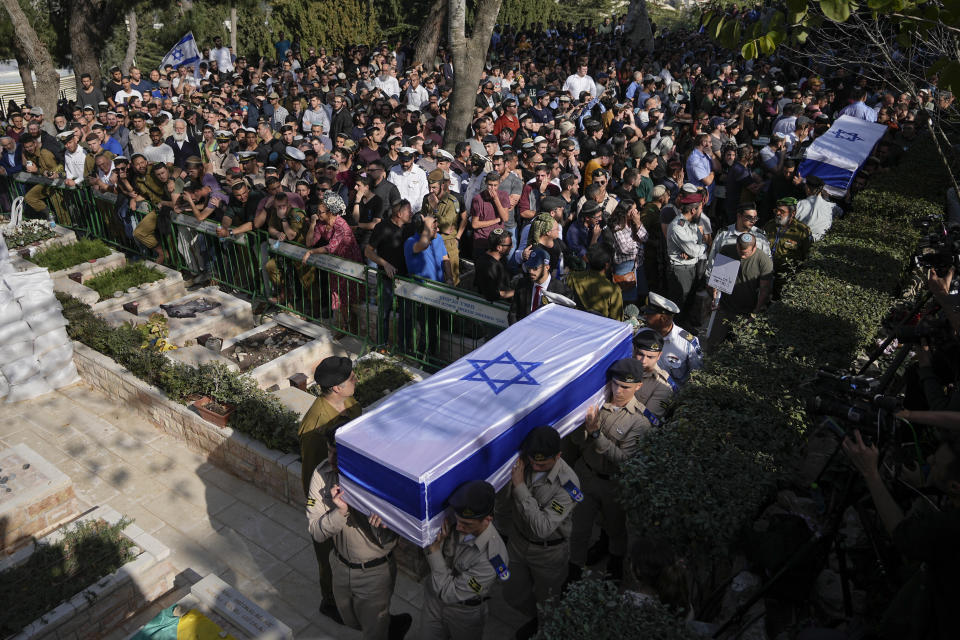 Israeli soldiers and mourners carry the flag-draped coffins of Hillel Yaniv, 21, and Yagel Yaniv, 19, during their funeral at Israel's national cemetery in Jerusalem, Monday, Feb. 27, 2023. The two brothers were killed Sunday in the West Bank town of Hawara by a Palestinian gunman who fled the scene. (AP Photo/Ohad Zwigenberg)