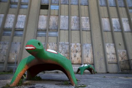 Two concrete playground turtles are seen outside the boarded up windows of Laura Ward School in Chicago, Illinois, United States, June 2, 2015. REUTERS/Jim Young