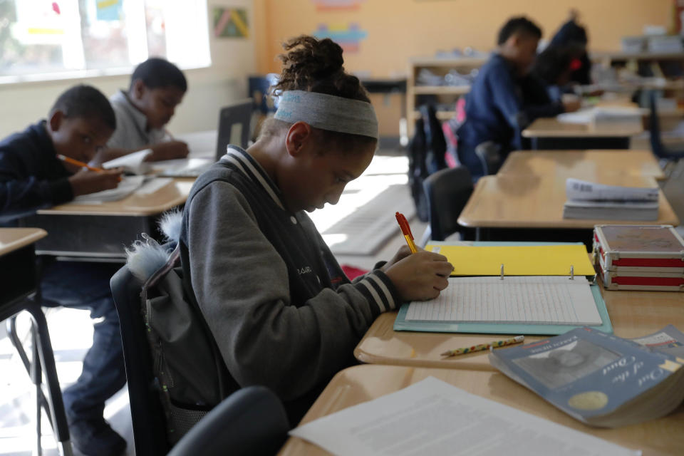 In this Tuesday, Dec. 18, 2018 photo, Breanna Johnson works on her assignment in her 6th grade english class at Alice M. Harte Charter School in New Orleans. Charter schools, which are publicly funded and privately operated, are often located in urban areas with large back populations, intended as alternatives to struggling city schools. (AP Photo/Gerald Herbert)