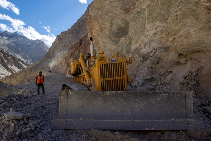 A Border Roads Organisation (BRO) worker operates a bulldozer on an under construction highway in the Ladakh region