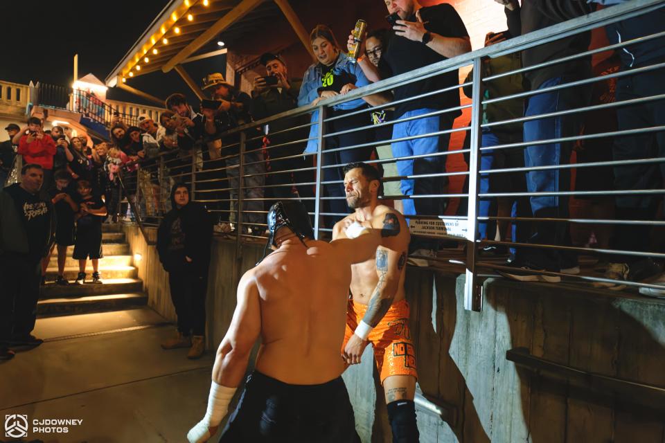 Matt Cross, performing in his Son of Havoc mask, delivers a chop to Dirty Dango against the patio railing at Jackson Terminal in the Old City neighborhood of downtown Knoxville.