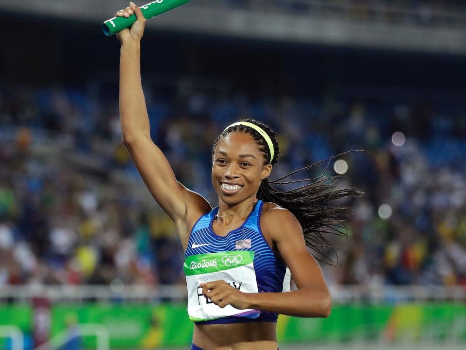 Allyson Felix holds up a baton at the Rio Olympics in 2016.