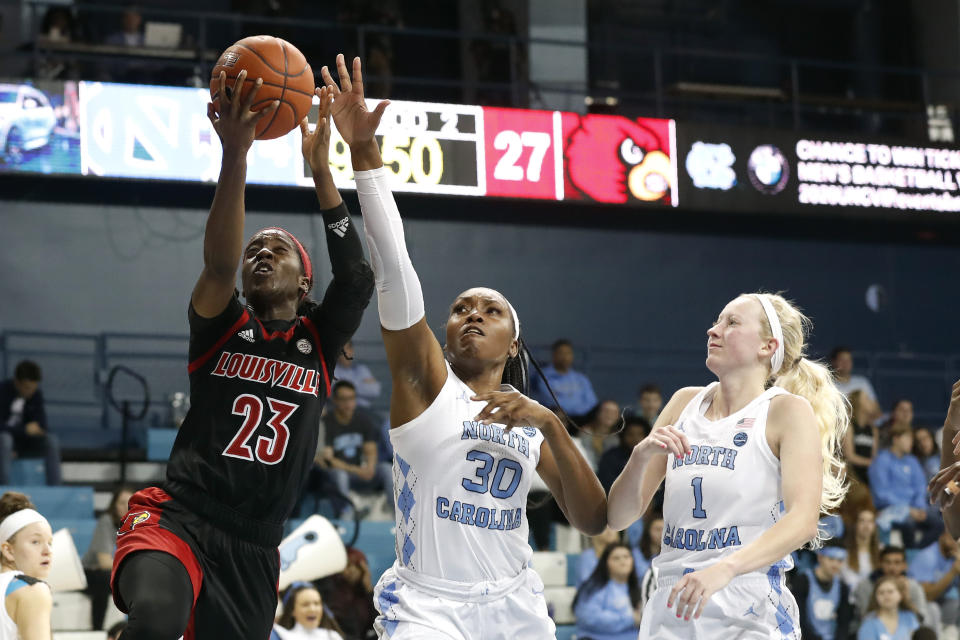 Louisville guard Jazmine Jones (23) shoots while North Carolina center Janelle Bailey (30) and guard Taylor Koenen (1) defend during the first half of an NCAA college basketball game in Chapel Hill, N.C., Sunday, Jan. 19, 2020. (AP Photo/Gerry Broome)