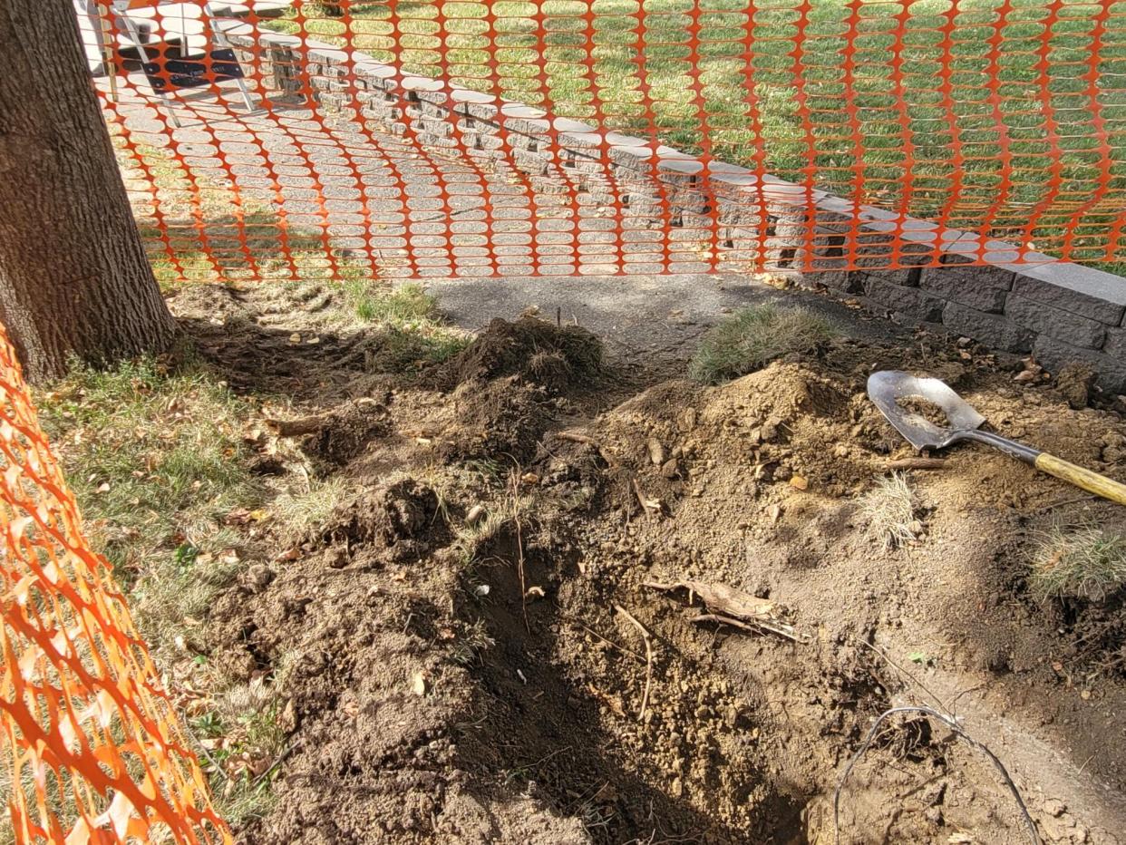 Left behind by a worker, a shovel lays in a trench dug in right of way as workers install fiber optic cable in Des Moines' West Drake neighborbhood.