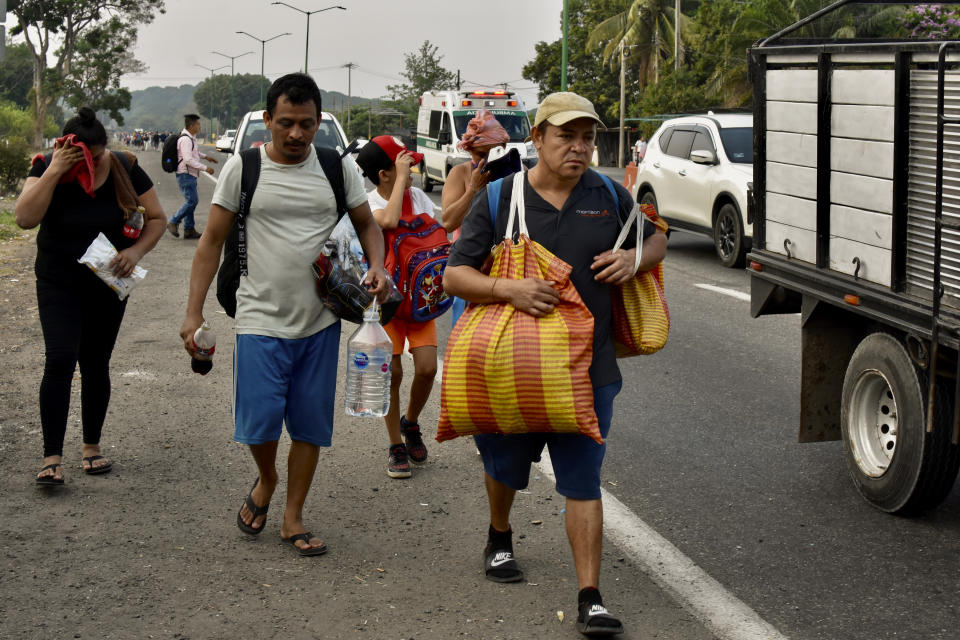 Migrants march to Huehuetan, Chiapas state, Mexico, Monday, April 24, 2023. About 3,000 migrants began walking before dawn for a second day of protest march demanding the end of detention centers like the one that caught fire last month, killing 40 migrants. (AP Photo/Edgar H. Clemente)