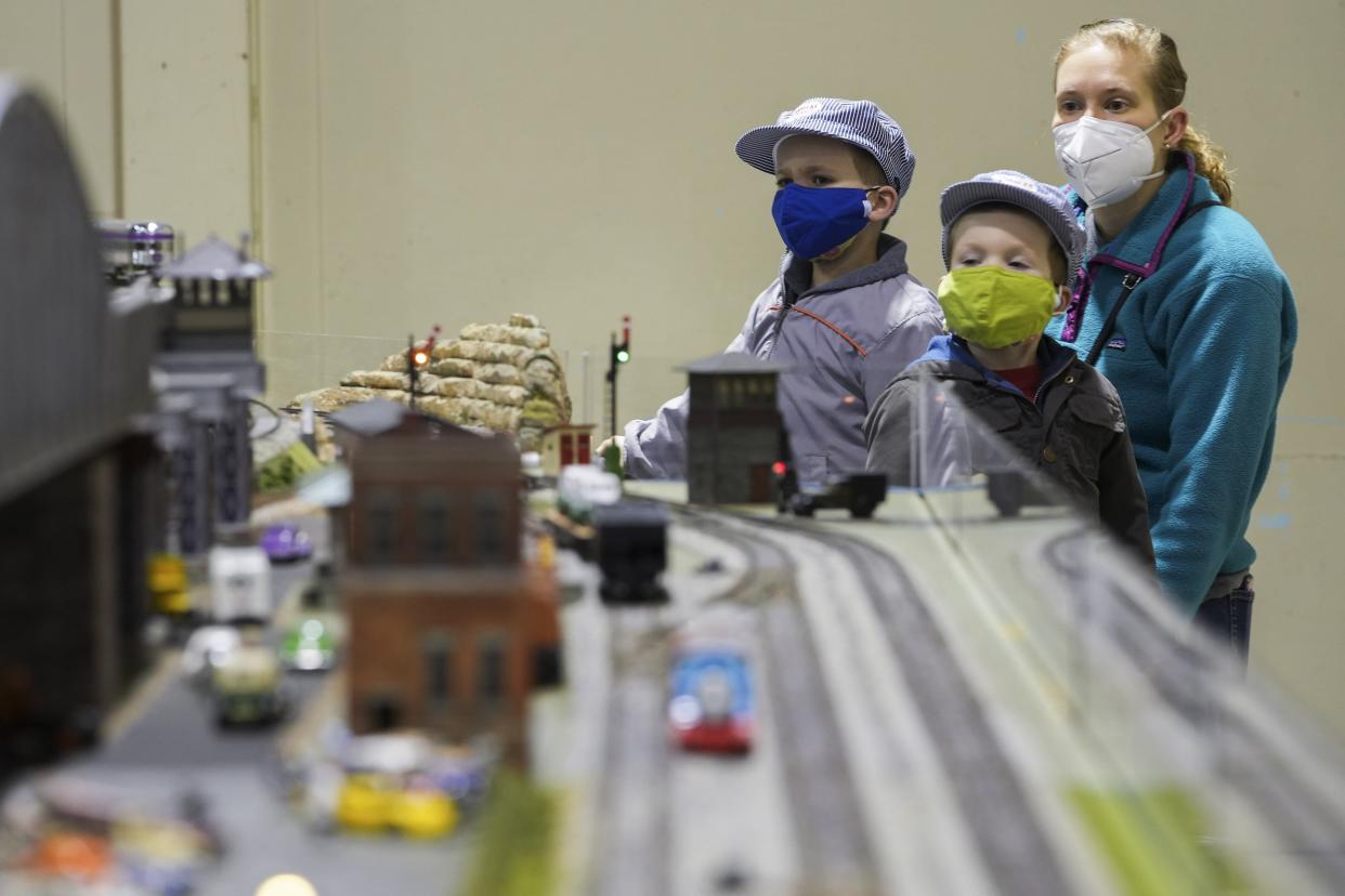 Brothers Stephen Coffman, 4, left, and Seth Coffman, 3, center, watch with their mother Malorie as a model train zips around a track during the Great Train Show at the Ohio Expo Center on Saturday. The two-day event featured about 40 exhibitors from across the country, as well as model train displays and workshops.